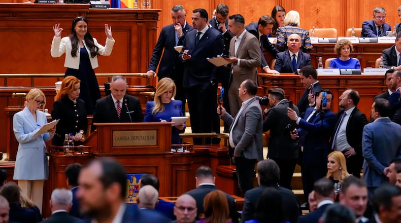 Romanian Prime Minister Ilie Bolojan, centre row third from right, sits as lawmakers vote during a no confidence vote in Bucharest, Romania, Tuesday, May 5, 2026. (AP Photo/Vadim Ghirda)