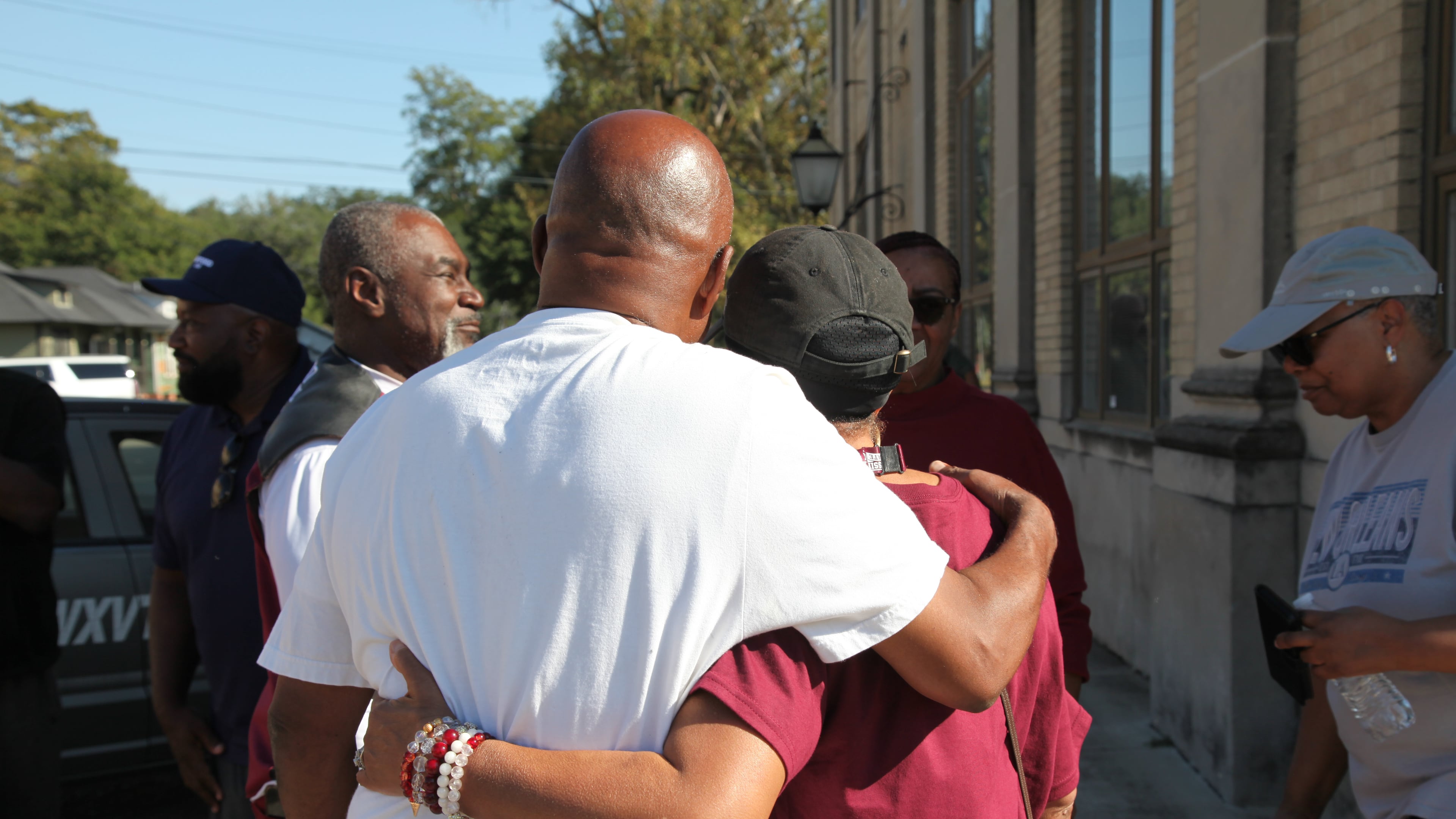 Friends and family of victims of a homecoming shooting embrace in downtown Leland, Miss., Saturday, Oct. 11, 2025. (AP Photo/Katie Adkins)