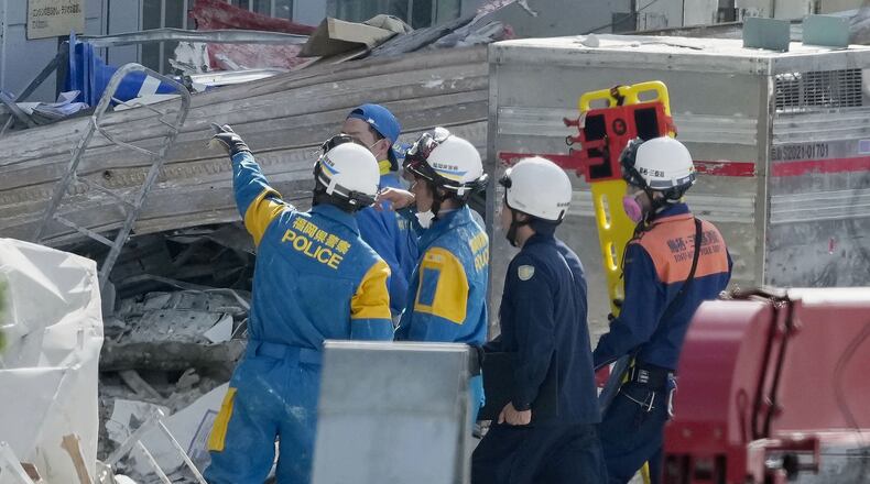 A firefighter carries a stretcher at AEON Mall shopping center, where an explosion occurred following a powerful earthquake, in Kashima, Kumamoto Prefecture, southern Japan, Thursday, July 30, 2026. (Kai Naito/Kyodo News via AP)