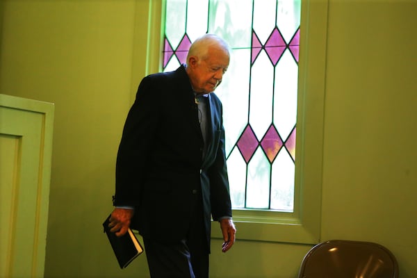 Jimmy Carter, 39th President of the United States, reverently enters the sanctuary with his Bible on Father's Day preparing to teach Sunday school at Maranatha Baptist Church on Sunday, June 15, 2014, in Plains. CURTIS COMPTON / CCOMPTON@AJC.COM