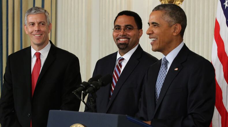 Former President Barack Obama flanked by Deputy Education Secretary John B. King Jr. (C) and Education Secretary Arne Duncan (L) at the White House in 2015. King succeeded Duncan as ed secretary for the final year of the Obama White House. (Photo by Chip Somodevilla/Getty Images)