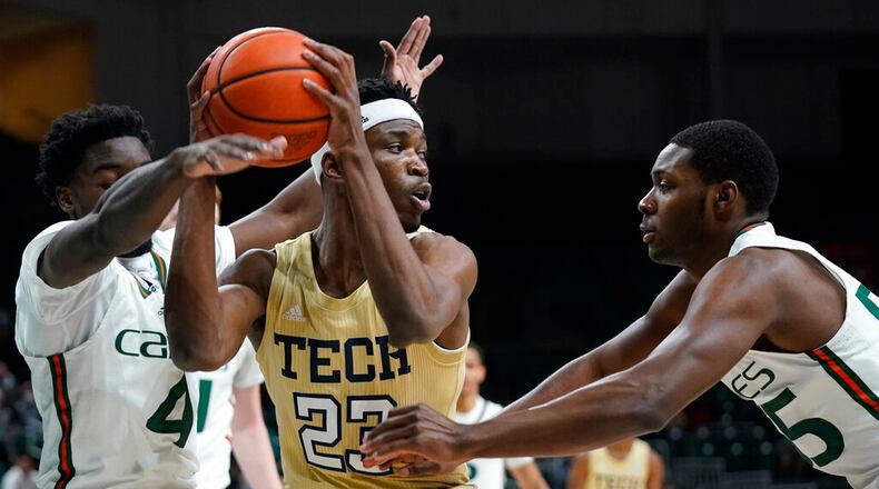 Georgia Tech forward Jordan Meka (23) looks for an opening past Miami guards Bensley Joseph (4) and Wooga Poplar (55) during the first half of an NCAA college basketball game, Wednesday, Feb. 9, 2022, in Coral Gables, Fla. (AP Photo/Wilfredo Lee)