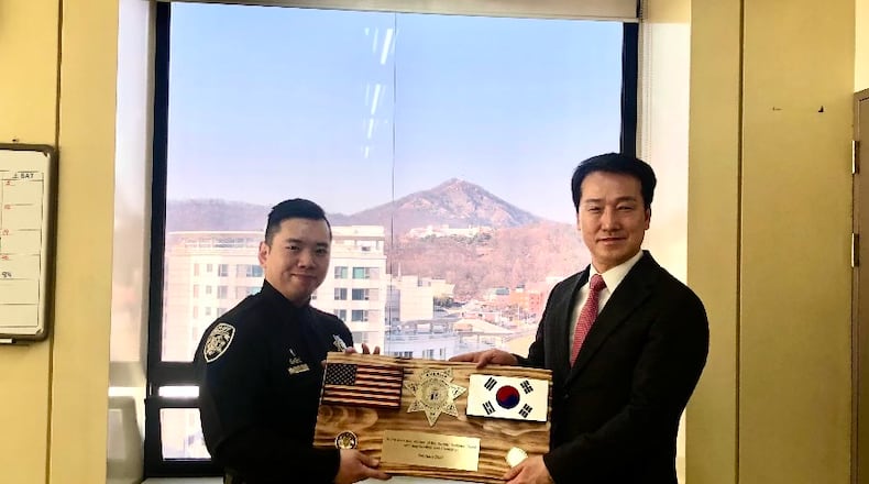 Cherokee Sheriff's Deputy Yee Lee presenting plaque to Senior Superintendent Man Suk Im.