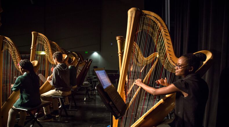 Drew Charter high school students at harp practice in December with their instructor, right. The head of the Georgia Charter Schools Association cites Drew as one of the state's most successful charters.