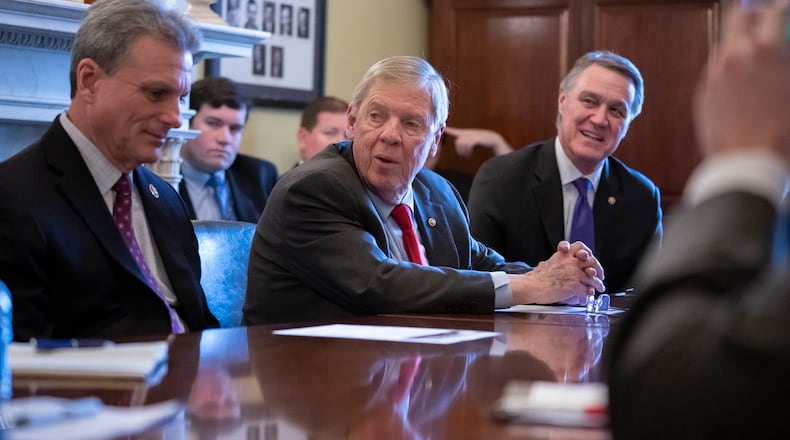 Sen. Johnny Isakson, R-Ga., flanked by Rep. Buddy Carter R-Ga., left, and Sen. David Perdue, R-Ga., right, leads a meeting with the Georgia Ports Authority and the Army Corps of Engineers to request full funding for the Savannah Harbor Expansion Project in the 2020 federal budget, on Capitol Hill in Washington, Thursday, Feb. 14, 2019. (AP Photo/J. Scott Applewhite)