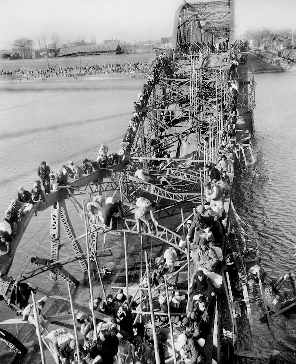 FILE - Residents from Pyongyang, North Korea, and refugees from other areas crawl over shattered girders of the city's bridge Dec. 4, 1950, as they flee south across the Taedong River to escape the advance of Chinese Communist troops. (AP Photo/Max Desfor, File)