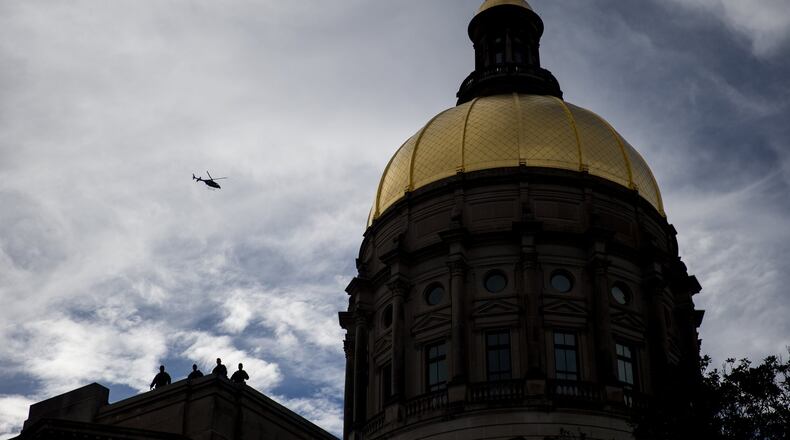 Police officers keep watch from the top of the Georgia State Capitol during the Atlanta March for Social Justice & Women, Saturday, Jan. 21, 2017, in Atlanta. BRANDEN CAMP/SPECIAL