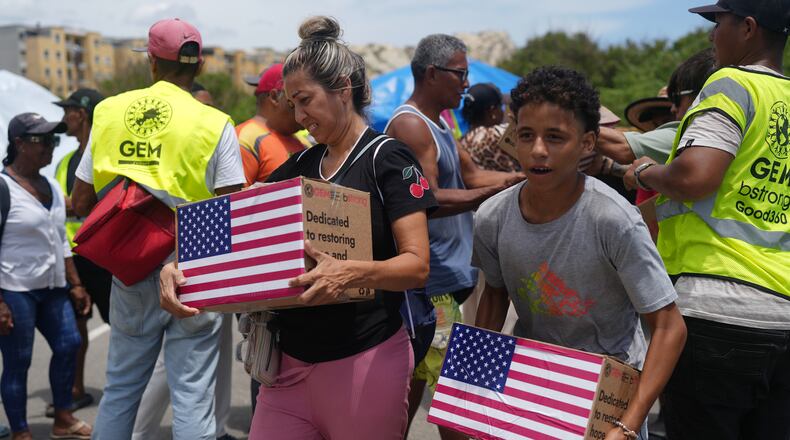People affected by the earthquakes carry U.S. humanitarian aid after receiving it in La Guaira, Venezuela, Wednesday, July 8, 2026. (AP Photo/Ariana Cubillos)