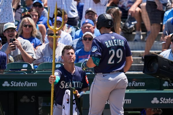 Seattle Mariners' Cal Raleigh (29), right, receives the home run trident from Dylan Moore (25) after hitting a home run during the first inning of a baseball game against the Chicago Cubs, Friday, June 20, 2025, in Chicago. (AP Photo/Erin Hooley)
