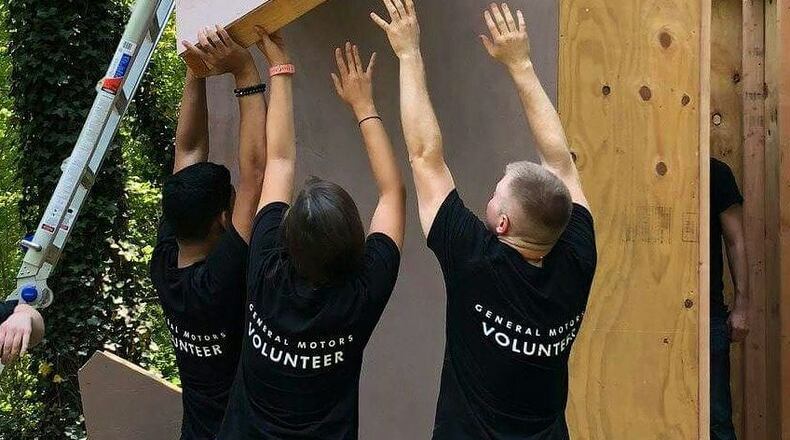 During a recent build, volunteers are shown raising a panel for one of the homes.