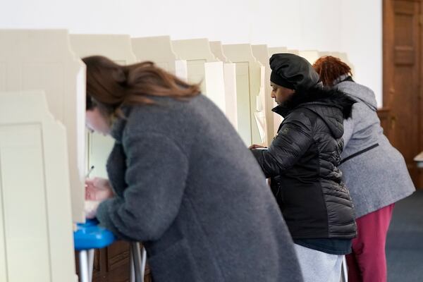 Tainesha Johnson (CQ), center, marks her ballot while voting at Centennial Hall at the Milwaukee Central Library on Election Day Tuesday, April 1, 2025, in Milwaukee. (AP Photo/Kayla Wolf)