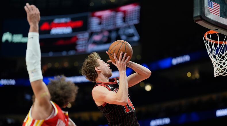 Chicago Bulls forward Matas Buzelis (14) drives past Atlanta Hawks guard Trae Young (11) during the first half of an NBA basketball game, Tuesday, Dec. 23, 2025, in Atlanta. (AP Photo/Mike Stewart)