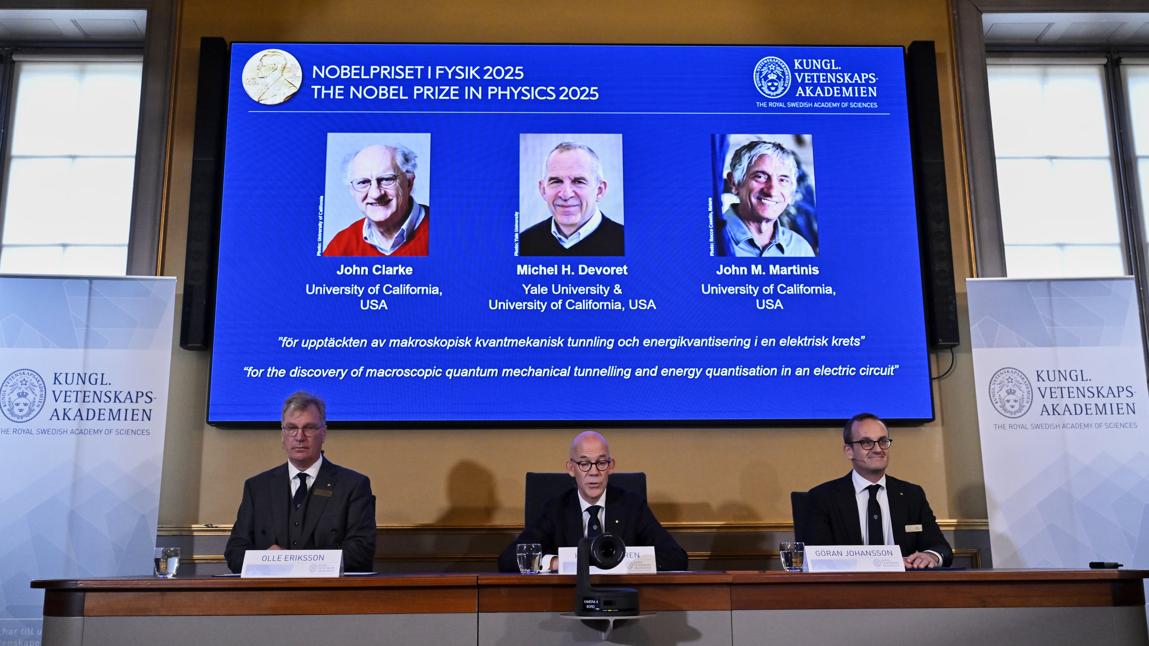 From left, Chair of the Nobel Committee for Physics Chair Olle Eriksson, Secretary General of the Swedish Academy of Sciences Hans Ellegren and Member of the Nobel Committee for Physics Goran Johansson announce John Clarke, Michel H Devoret and John M. Martinis, on screen behind, as the recipients the Nobel Prize in Physics, at the Nobel Assembly of the Karolinska Institutet, in Stockholm, Sweden, Tuesday, Oct. 7, 2025. (Christine Olsson/TT News Agency via AP)