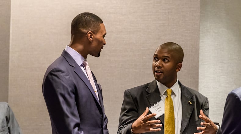 Georgia Tech senior associate Marvin Lewis (right) speaks with former Yellow Jackets basketball star Chris Bosh at the athletic department's hall of fame induction banquet in October 2016. (Danny Karnik/Georgia Tech Athletics)