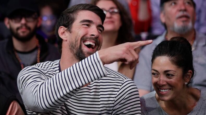 In this March 21, 2017, file photo, Michael Phelps and his wife, Nicole Johnson, smile during an NBA basketball game between the Los Angeles Lakers and the Los Angeles Clippers in Los Angeles.  (AP Photo/Jae C. Hong, File)