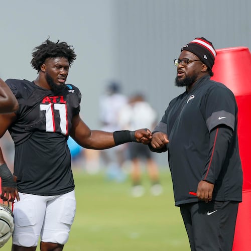 Atlanta Falcons linebackers Jalon Walker (center) and James Pearce Jr. (left) speak with defensive line coach Nate Ollie before their joint practice with the Tennessee Titans on Wednesday, Aug. 13, 2025, in Flowery Branch. Walker was held out of Friday's game with an injury. (Miguel Martinez/AJC)