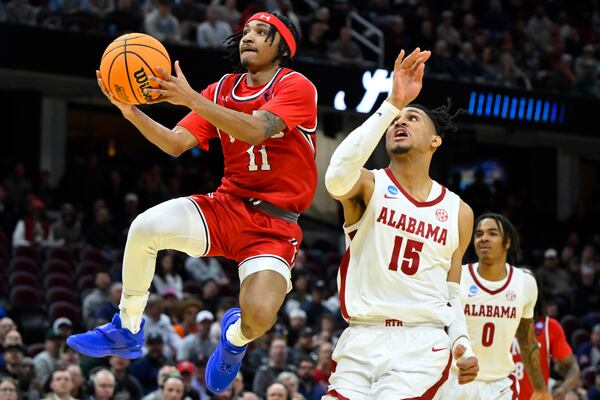 Robert Morris guard DJ Smith (11) drives to the basket passt Alabama forward Jarin Stevenson (15) in the first half in the first round of the NCAA college basketball tournament, Friday, March 21, 2025, in Cleveland. (AP Photo/David Richard)