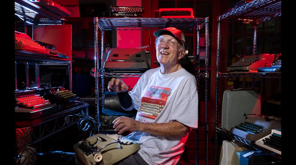 Tom Rehkopf poses for a portrait in his home workshop in Roswell on Sunday, October 5, 2025. Rehkopf has collected around 1,000 typewriters. (Arvin Temkar / AJC)
