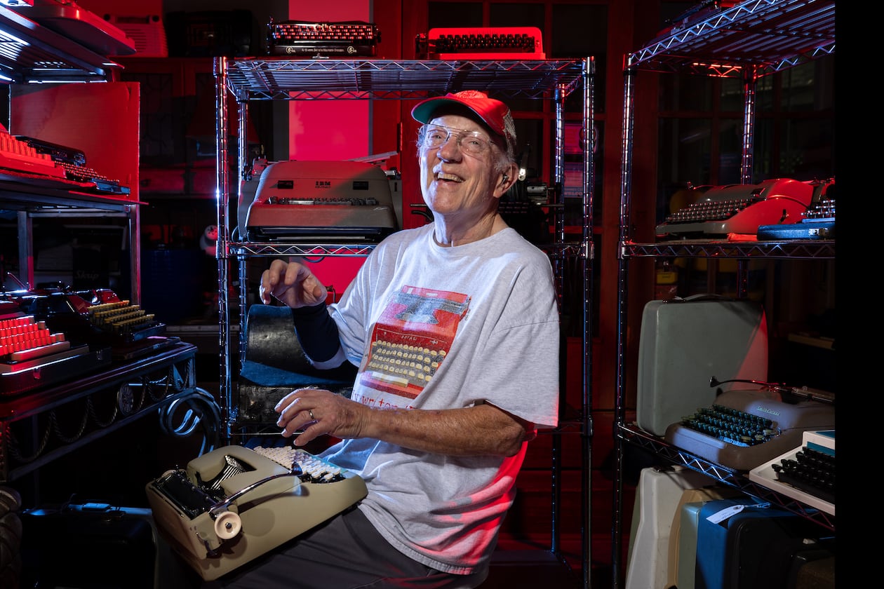 Tom Rehkopf poses for a portrait in his home workshop in Roswell on Sunday, October 5, 2025. Rehkopf has collected around 1,000 typewriters. (Arvin Temkar / AJC)