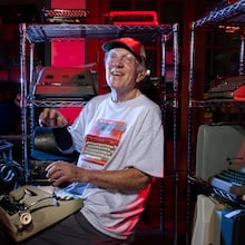 Tom Rehkopf poses for a portrait in his home workshop in Roswell on Sunday, October 5, 2025. Rehkopf has collected around 1,000 typewriters. (Arvin Temkar / AJC)