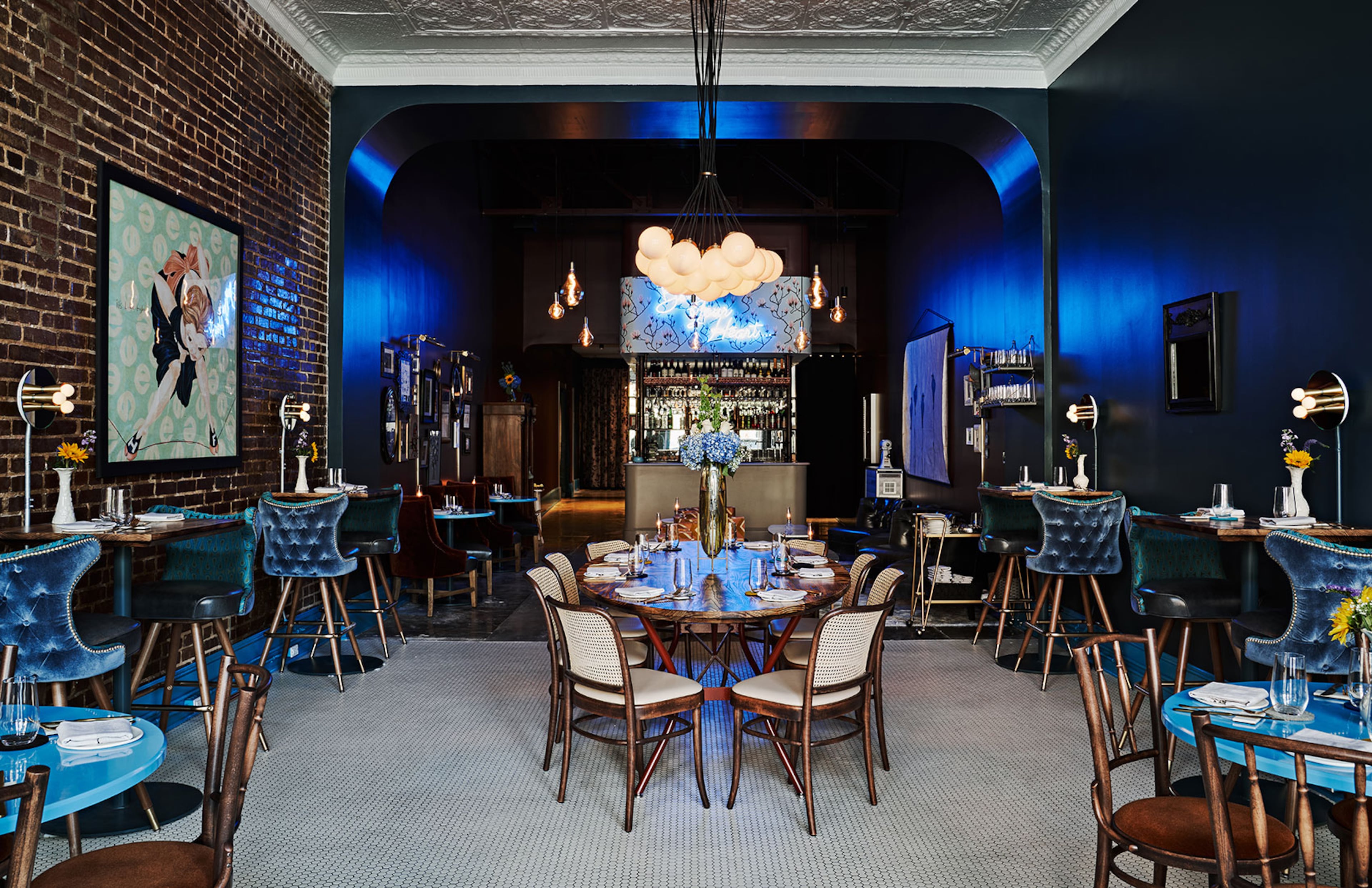 A neon blue “Bless Your Heart” sign above the service bar adds to the tongue-in-cheek fun at this modern Southern restaurant. (Courtesy of Southern Belle)