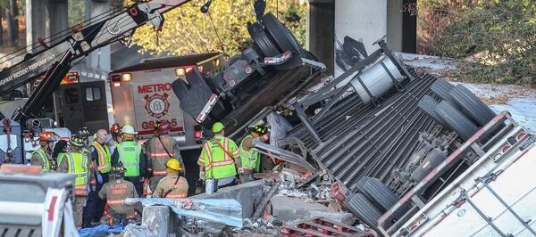 Two people were trapped in a tractor-trailer Thursday on I-285 westbound at I-75 southbound in Clayton County. Both were rescued. JOHN SPINK / JSPINK@AJC.COM