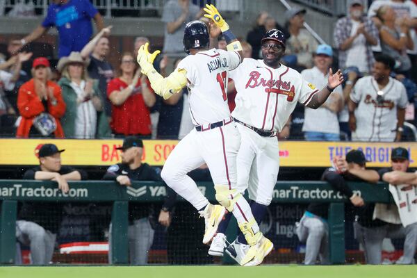 Ronald Acuña Jr. celebrates his unusual Thursday night home run with third base coach Tommy Watkins. (Miguel Martinez/AJC)
