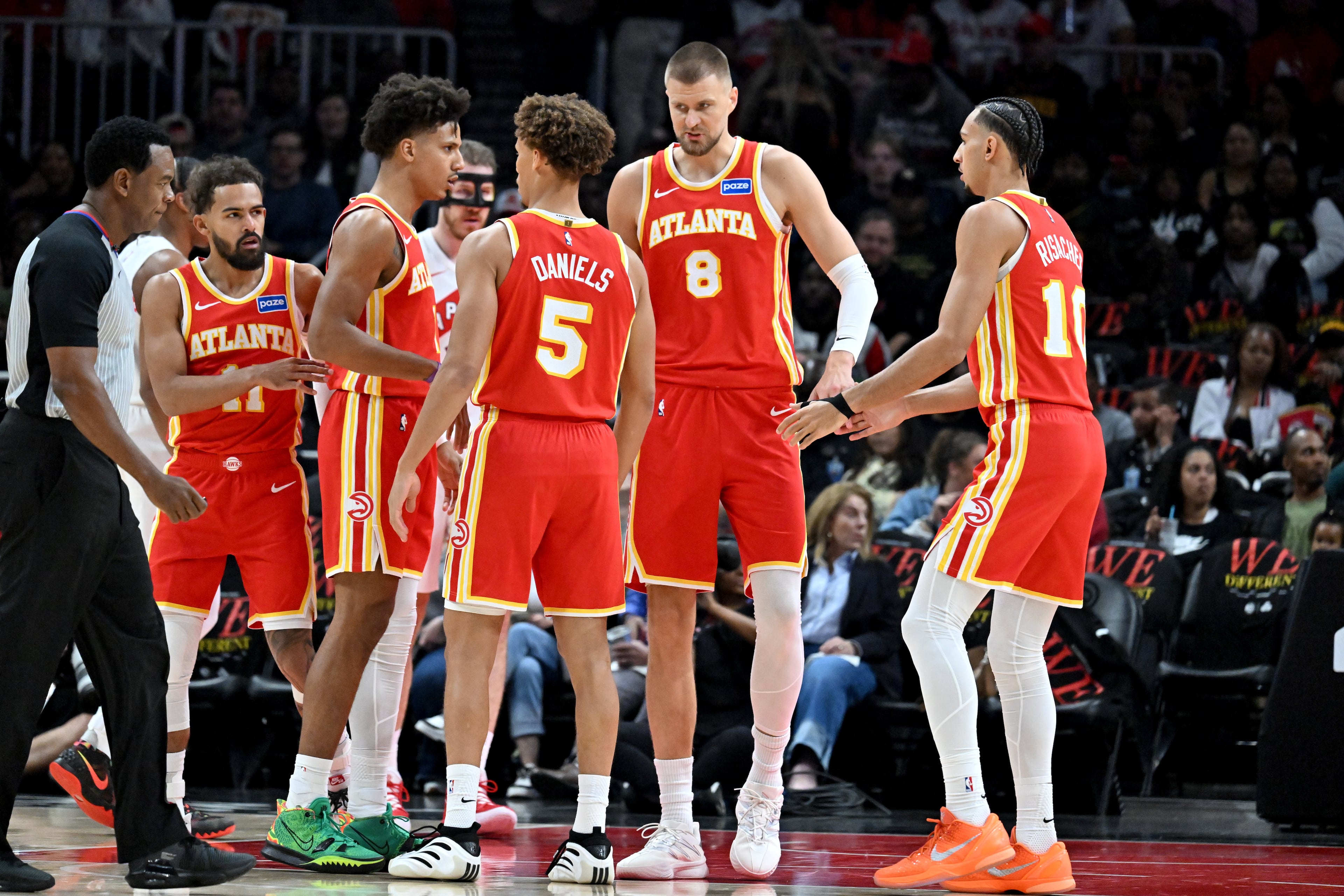 Atlanta Hawks forward/center Kristaps Porziņģis (8) and other players confer during the first half in the home opener at State Farm Arena, Thursday, October 22, 2025, in Atlanta. (Hyosub Shin / AJC)