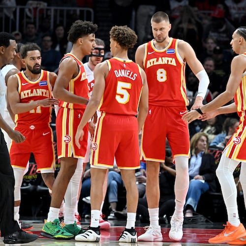 The Hawks confer during the first half in the home opener at State Farm Arena in October. (Hyosub Shin/AJC)