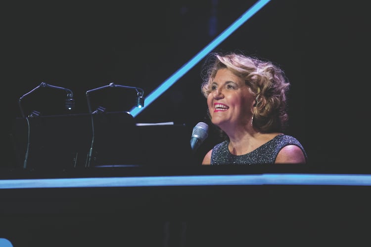 Ann-Carol Pence has served as “Christmas Canteen’s” music director, arranger and conductor for 30 years. Mixing music, comedy skits and dance numbers, the Aurora Theatre holiday show continues through Dec. 21. (Photo by Casey Gardner Ford)