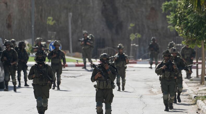 Israeli army soldiers patrol the streets of the occupied West Bank village of Qusra, south of Nablus, Thursday, Aug. 13, 2026. (AP Photo/Majdi Mohammed)