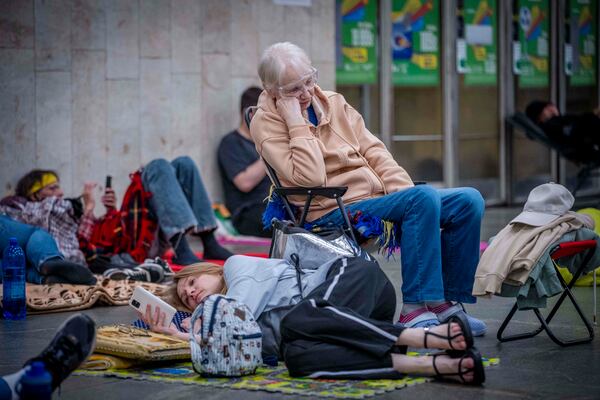 People hide in a metro station, being used as a bomb shelter, during a Russian drones attack in Kyiv, Ukraine, early hours Saturday, July 5, 2025. (AP Photo/Dan Bashakov)