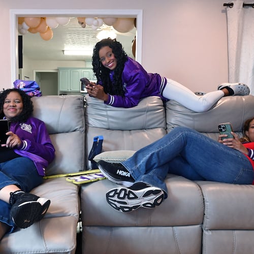 Selita Boyd, left, her sister Aalja Boyd, right, and her niece Jemini Powell, center, pose as they do when playing Candy Crush on Tuesday, Aug. 4, 2026, in Stone Mountain. All three have competed in a $1 million Candy Crush tournament, where the top 10 players compete. (Hyosub Shin/AJC)