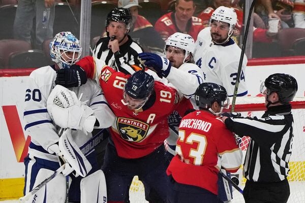 Florida Panthers left wing Matthew Tkachuk (19) and center Brad Marchand (63) scuffles with Toronto Maple Leafs goaltender Joseph Woll (60) and defenseman Simon Benoit, center, right, after the Maple Leafs won Game 6 of a second-round NHL hockey playoff series, Friday, May 16, 2025, in Sunrise, Fla. (AP Photo/Lynne Sladky)