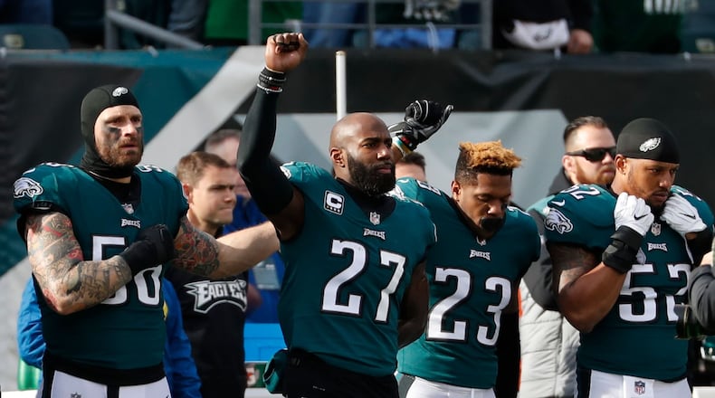 Philadelphia Eagles' Chris Long, from left, Malcolm Jenkins and Rodney McLeod gesture during the national anthem before an NFL football game against the Chicago Bears, Sunday, Nov. 26, 2017, in Philadelphia.