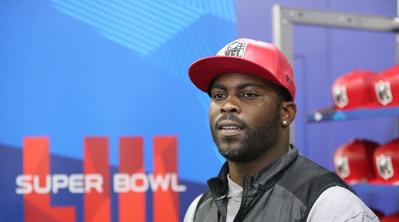 Former Falcons and Eagles quarterback Michael Vick wears one of his special edition New Era #7 hats on sale in the NFL Shop at the Super Bowl Experience on Thursday, Jan. 31, 2019, in Atlanta. Curtis Compton/ccompton@ajc.com