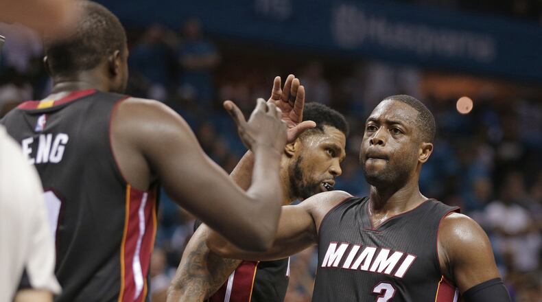 FILE - In this April 29, 2016, file photo, Miami Heat’s Dwyane Wade (3) gives a high-five to Luol Deng after Game 6 of an NBA basketball playoffs first-round series against the Charlotte Hornets in Charlotte, N.C. Wade still has every hope of finishing his NBA career in the same manner that it began, wearing a Heat uniform. That’s the good news for Heat fans. Now comes the tough part, that being Wade and the team figuring out how to make that a reality. (AP Photo/Chuck Burton, File)