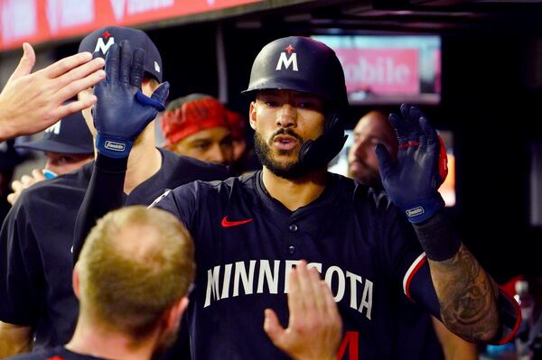 Minnesota Twins shortstop Carlos Correa (4) celebrates his solo homerun in the dugout against the Atlanta Braves during the fourth inning in a baseball game at Truist Park, Saturday, April 19, 2025, in Atlanta. (AP Photo/ John David Mercer)