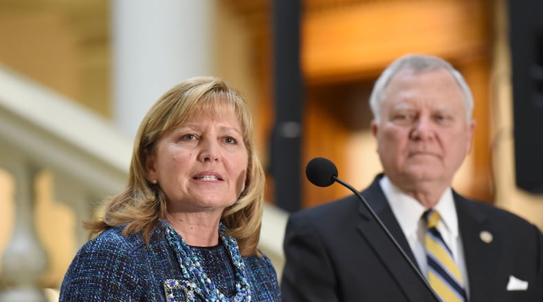Julie Miller-Phipps, president of Kaiser Foundation Health Plan of Georgia, speaks as Gov. Nathan Deal looks during a press conference to announce an expansion plan of Kaiser Permanente. The health care and coverage giant will create 800 jobs at a new call center in Gwinnett County. HYOSUB SHIN / HSHIN@AJC.COM
