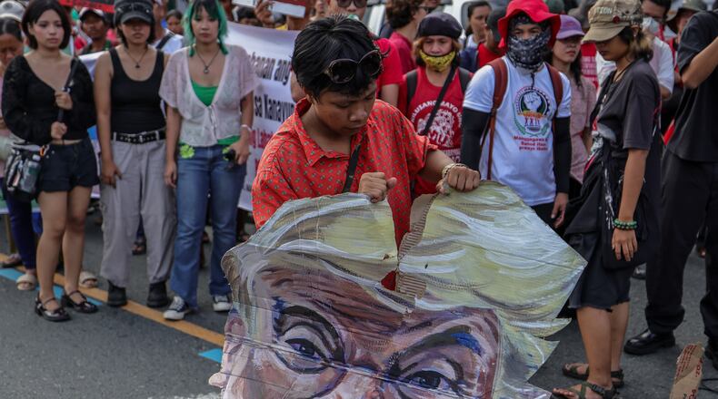 A protester destroys an effigy of U.S. President Donald Trump during a protest march in Quezon City, Philippines Monday, July 27, 2026, ahead of the State of the Nation Address by President Marcos Jr. (AP Photo/Gerard Carreon)