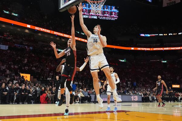 Miami Heat forward Duncan Robinson (55) drives to the basket as Memphis Grizzlies center Zach Edey (14) defends during the first half of an NBA basketball game, Thursday, April 3, 2025, in Miami. (AP Photo/Marta Lavandier)