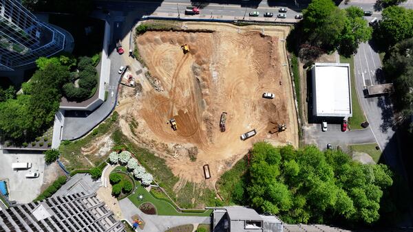 Heavy equipment works the land between Peachtree and West Peachtree Streets on 14th Street, on Thursday, April 9, 2026. The area is going to be transformed into a park. (Miguel Martinez/AJC)