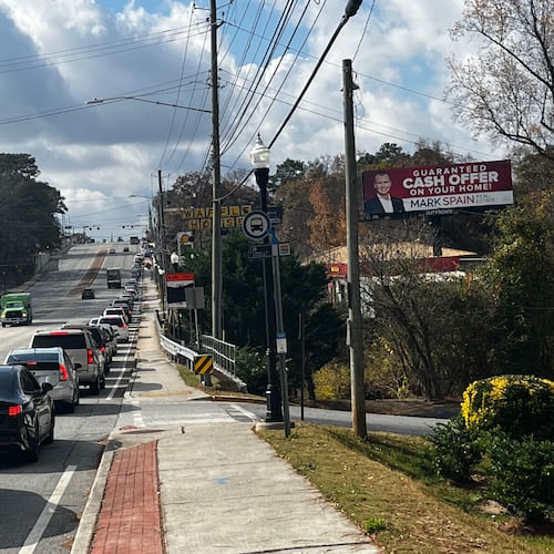 A line of cars on Buford Highway makes it way to the Latin American Association, site of a food distribution event, on Saturday, Nov. 22, 2025. Dozens of community members also made their way on foot. (Lautaro Grinspan/AJC)