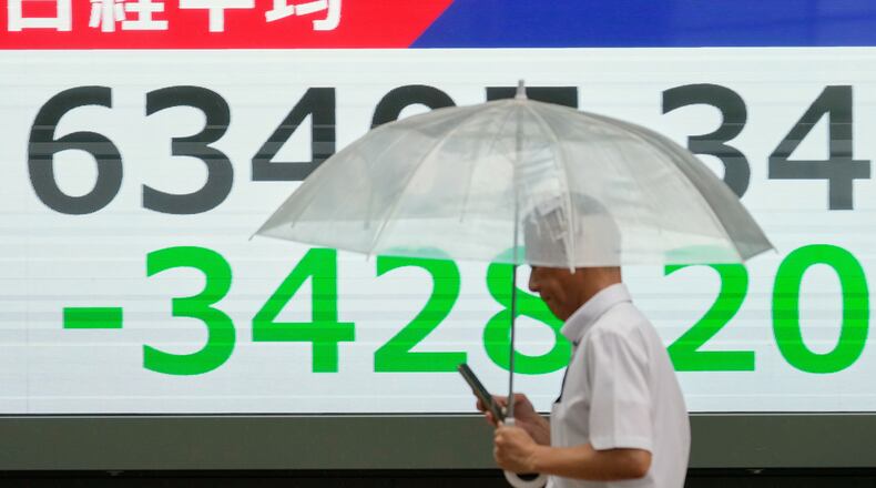 A person walks in front of an electronic stock board showing Japan's Nikkei index at a securities firm Friday, July 17, 2026, in Tokyo. (AP Photo/Eugene Hoshiko)
