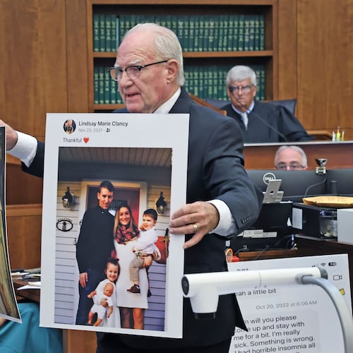 Defense attorney Kevin Reddington holds up a picture of th Clancy family before the murders during closing arguments in the Lindsay Clancy murder trial at Plymouth Superior Court in Plymouth, Mass., Thursday, Aug. 27, 2026. (Greg Derr/The Patriot Ledger via AP, Pool)