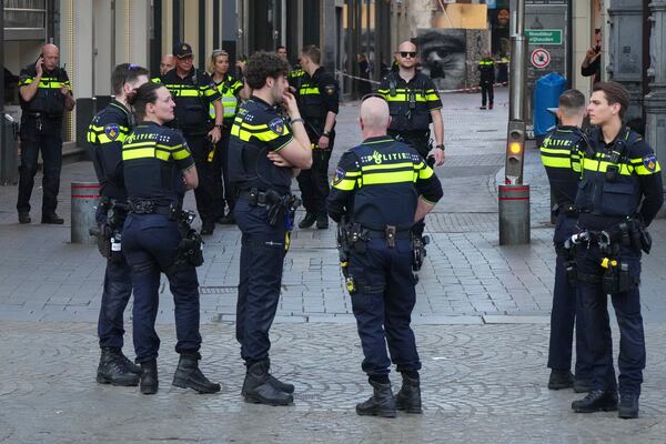 Police officers gather not far from the area after a stabbing near Dam Square in central Amsterdam, Thursday, March 27, 2025. (AP Photo/Peter Delong)