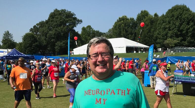 Jim Jochum proudly shows his shirt after completing AJC Peachtree Road Race.