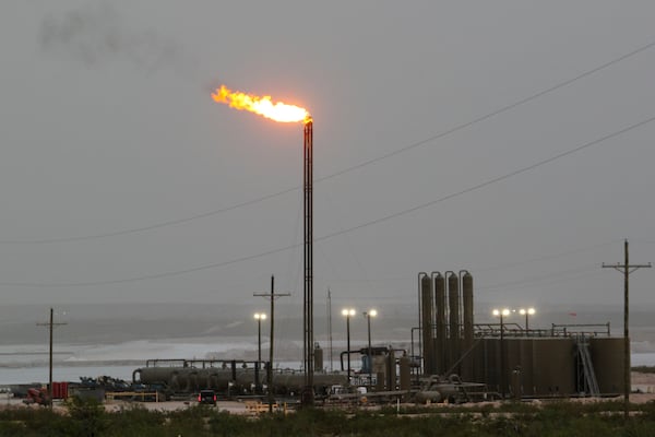 Strong winds kick up dust as a facility in the Permian Basin flares natural gas east of Carlsbad, N.M., on Monday, May 19, 2025. (AP Photo/Susan Montoya Bryan)