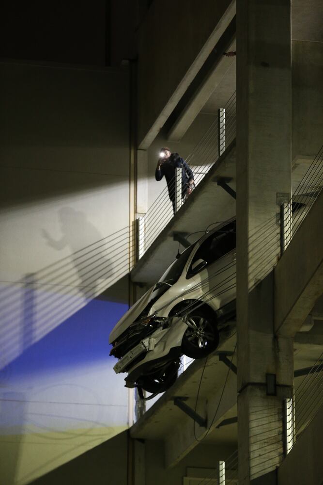 Car dangles from parking deck