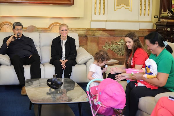 In this photo released by the Miraflores press office, Venezuelan President Nicolas Maduro and his wife first lady Cilia Flores, left, sit with 2-year-old Maikelys Espinoza and mother Yorely Escarleth Bernal Inciarte, second from right, on the day the mother and daughter were reunited, at Miraflores presidential palace in Caracas, Venezuela, Wednesday, May 14, 2025. The U.S. deported Bernal to Venezuela on April 25 and sent the child's father to a maximum-security prison in El Salvador in March. (Zurimar Campos/Miraflores press office via AP)